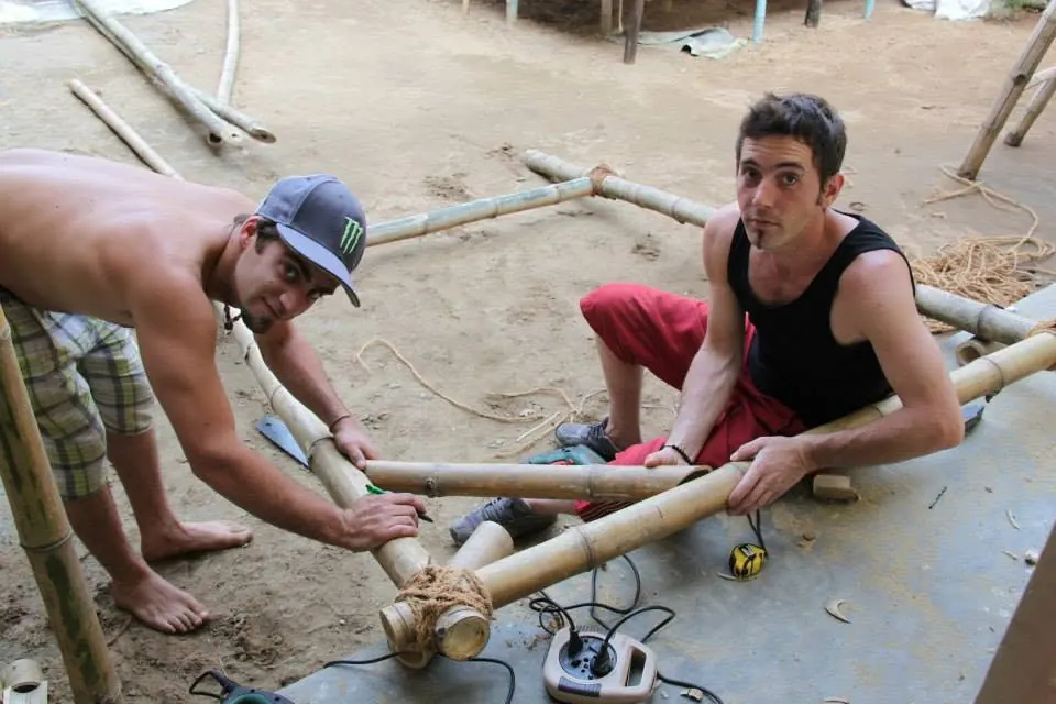 Deux volontaires construisent une structure en bambou à l'école